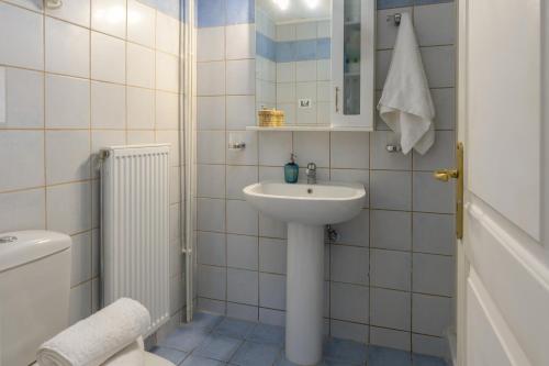Un baño blanco con lavabo e inodoro. en Vivian's Villa - Endless View, en Svoronata