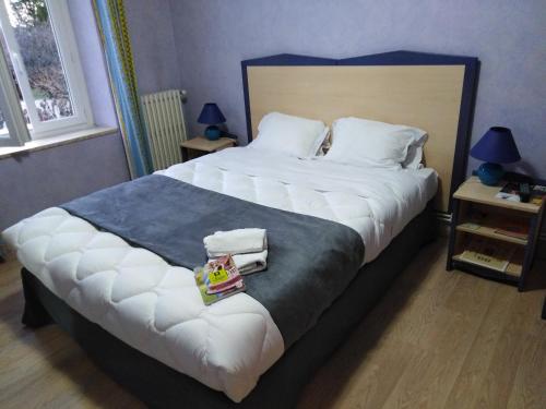 a bedroom with a large bed with towels on it at Logis Hotel Des Voyageurs Restaurant La Bonne Tabl'Hay in Livron-sur-Drôme