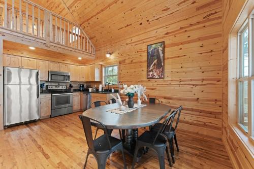 a kitchen with a table and chairs and a refrigerator at Cabin 4 Mtn View Cabin Near River with Fire Pit and Hot Tub in Jasper