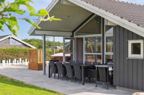a patio with chairs and a table on a house at Activity House - Flovt Strand, Haderslev in Haderslev