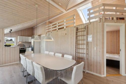 a dining room with a table and white chairs at Activity House - Flovt Strand, Haderslev in Haderslev