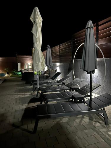 a row of lounge chairs with umbrellas at night at Kuća za odmor Mladen i Martina in Slavonski Brod
