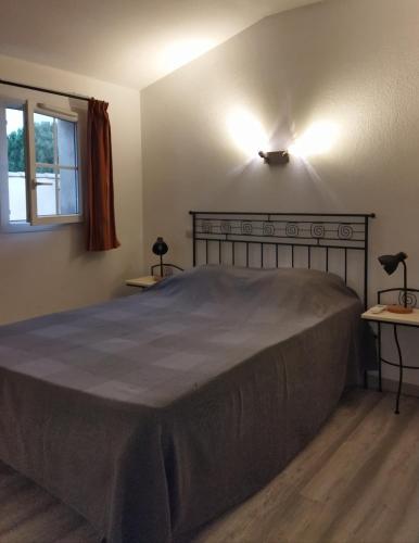 - une chambre avec un grand lit et 2 tables dans l'établissement Villa 45 M2 dans parc arboré avec piscine, à Gallargues-le-Montueux