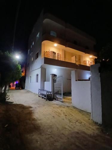 un edificio blanco con balcón por la noche en Nopian 1, en Luxor