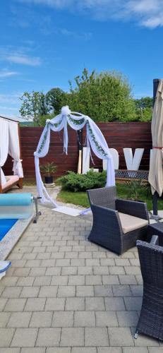 a wedding ceremony with a white arch and chairs at Kuća za odmor Mladen i Martina in Slavonski Brod