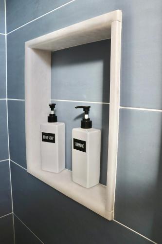 a bathroom shelf with two soap dispensers on it at Nido del Mar in Lendinuso