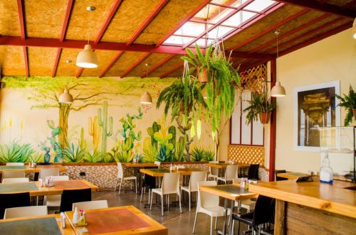 a restaurant with tables and chairs and plants on the wall at Hotel Oro Negro in Talara
