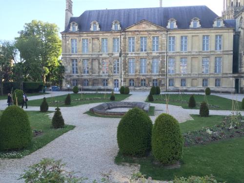 un grand bâtiment avec un jardin en face dans l'établissement Suite K, à Reims
