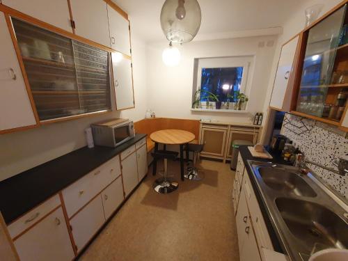 a small kitchen with a table and a sink at Wolfs Balkonruhe, geräumig S-Bahn Krottenbach in Vienna