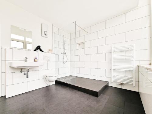 a white bathroom with a sink and a toilet at Tolstov Apartments - City Center Apartments with 5 Rooms - 10 Min Messe DUS in Düsseldorf