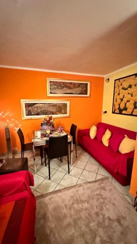 a living room with a red couch and a table at Casa di Cricci in Sestriere