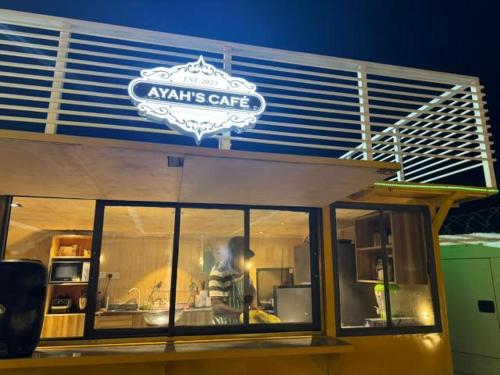 a man standing in the window of a restaurant at Ayahs Court in Abuja