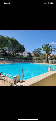 une grande piscine bleue avec des arbres en arrière-plan dans l'établissement Merazur, à Fréjus