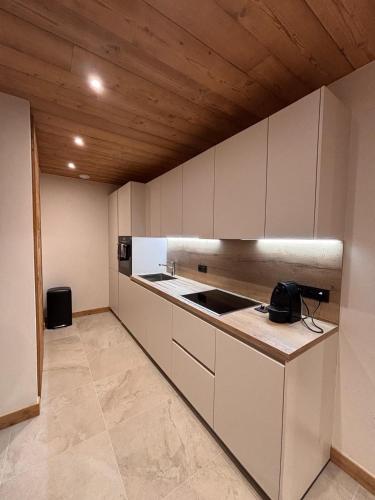 une cuisine avec des armoires blanches et un comptoir dans l'établissement Résidence Frond'Neige, à Morzine