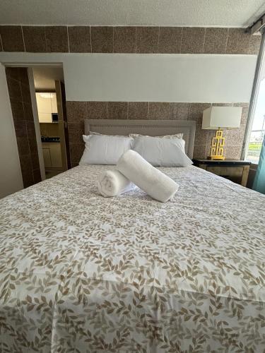 a bed with a rolled up towel on top of it at Isla Verde Modern Apartment with Pool in San Juan