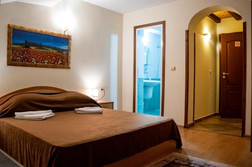 a bedroom with a bed with two towels on it at Matsurev Han in Bansko