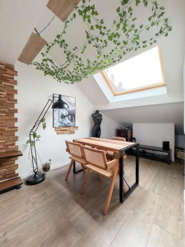 une salle à manger avec une table et une lucarne dans l'établissement Duplex-centre ville, à Caen