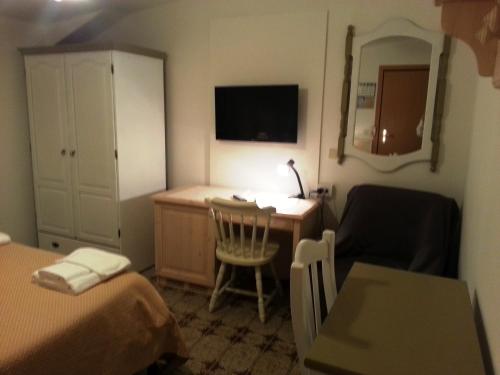 a hotel room with a desk and a bed and a chair at Dogana Vecchia - Hotel & Residence B&B Ristorante & Pizzeria in Trivignano Udinese