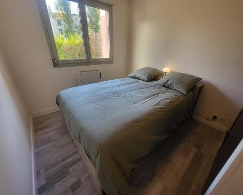 un lit dans une petite pièce avec une fenêtre dans l'établissement La Résidence des Poètes, à Dijon