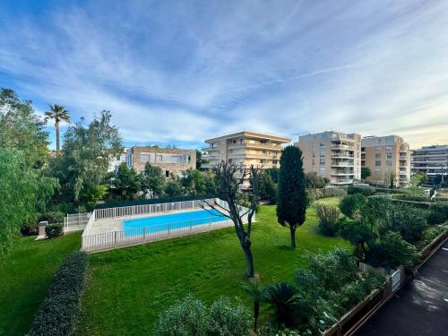 un parc avec une piscine dans une ville dans l'établissement Le Lys - Apt 4 Prs - clim - piscine - parking, à Antibes