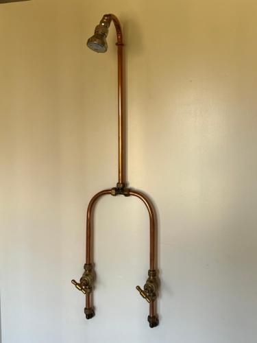 a lamp on a wall with a light on it at Plett Yellowwood Tiny House in Plettenbergbaai