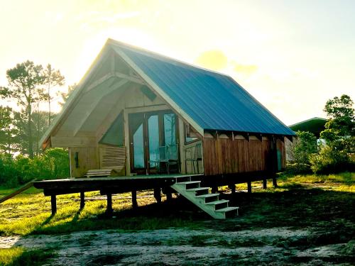 a small house with a blue roof on a dock at Plett Yellowwood Tiny House in Plettenbergbaai