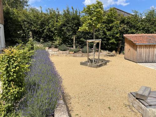 a garden with a bench and a swing at LandQuartier - La Primera in Dürrröhrsdorf