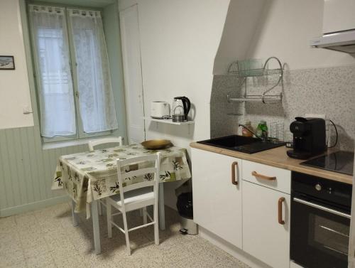 une petite cuisine avec une table et un évier dans l'établissement Appart 2 pièces proche de Nausicaá et de la plage, à Boulogne-sur-Mer