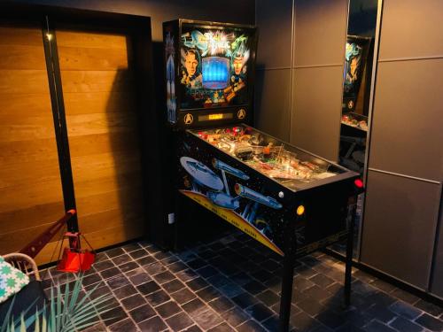 a pinball machine is in a room with at Maisonette jacuzzi terrasse Lille in Saint-André-lez-Lille