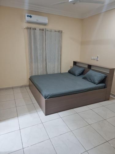 a bedroom with a bed with blue pillows on it at Earl Lodge in Ashalebotwe