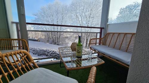 une bouteille de vin posée sur une table devant une fenêtre dans l'établissement Ô Rives du Doubs - La campagne à la ville, à Pontarlier