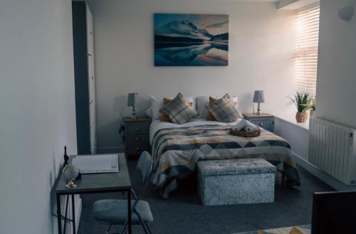 a bedroom with a bed with pillows and a table at Urban View Apartment - Sleeps 6 in Newport