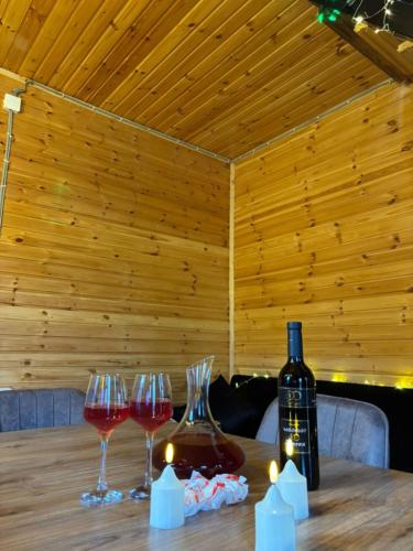 a table with wine glasses and a bottle of wine at Turo House Meris in Inasharidzeebi