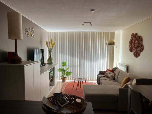 a living room with a couch and a table at Duinhelm Vakantiestudio Mariakerke - A cosy place by the sea in Ostend