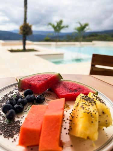 a plate of fruit on a table next to a pool at Fina Estampa Country Hotel by HMC - Mayores de 10 años - in Támesis