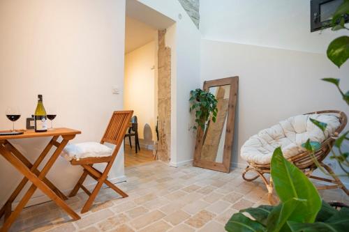 - un salon avec une table, des chaises et une porte dans l'établissement Le Saint Baudile 80sqm parking AC church view, à Nîmes