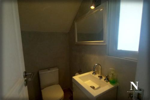 a bathroom with a toilet and a sink and a window at Hermosa casa en Costa Esmeralda in Costa Esmeralda