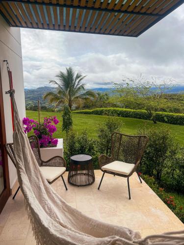 a hammock on a patio with chairs and a table at Fina Estampa Country Hotel by HMC - Mayores de 10 años - in Támesis