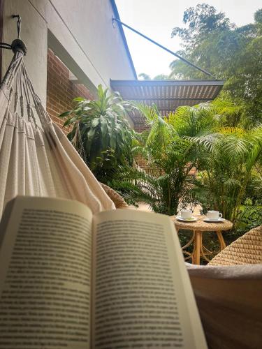 an open book sitting on a hammock on a patio at Fina Estampa Country Hotel by HMC - Mayores de 10 años - in Támesis