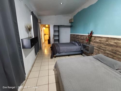 a bedroom with two beds and a blue wall at Casa Cartagena in Zamora de Hidalgo