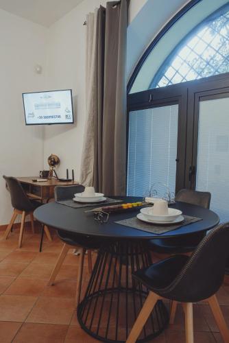 een eetkamer met een tafel en stoelen en een raam bij Royal Palace B&B in Caserta