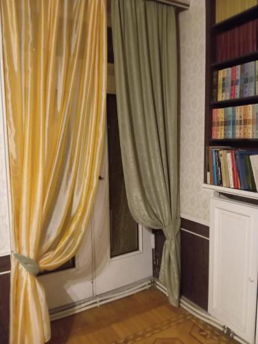a door with curtains and a book shelf with books at Royal Boutique Hotel on Kievyan in Yerevan