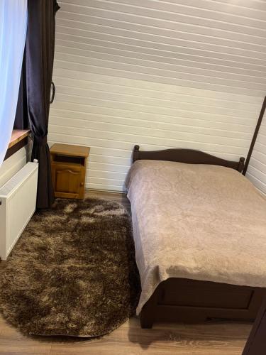 a bedroom with a bed and a rug at Незабутні Карпати in Vorokhta
