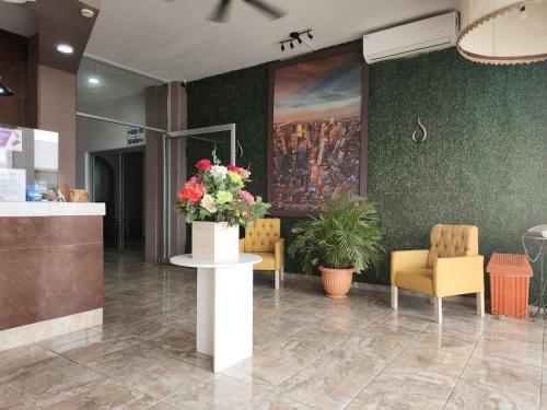 a lobby with a table with a bouquet of flowers at BB INN in Nuevo Vallarta 