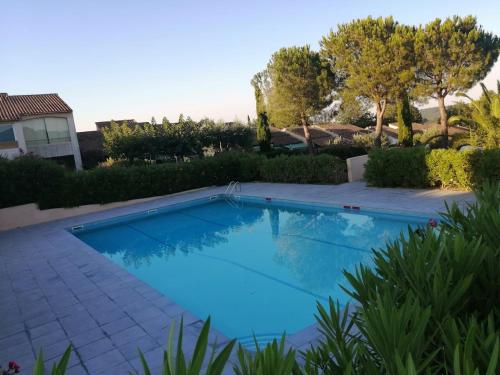 une grande piscine bleue dans une cour dans l'établissement DUPLEX with terrace in residence and pool, à Cogolin