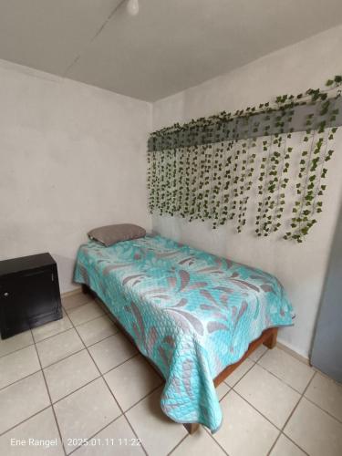 a small bedroom with a bed and a television at Casa Cartagena in Zamora de Hidalgo