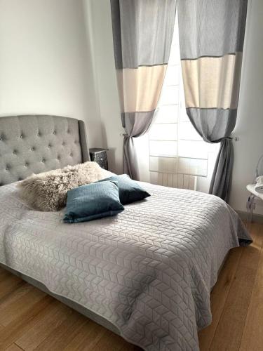 une chambre avec un lit avec des oreillers bleus et une fenêtre dans l'établissement 3P Cannes Centre 3min Palais des Festivals,Top location, à Cannes