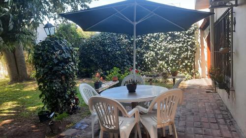 a table and chairs with an umbrella on a patio at Nel's Casa Hostel A 15 minutos de Aeropuerto Ezeiza in Monte Grande