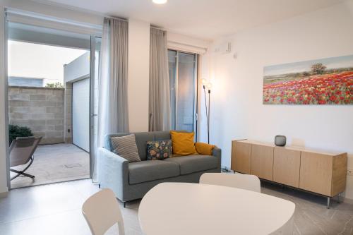 een woonkamer met een bank en een tafel bij Appartamento Guglielmo in Oristano
