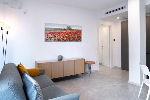 een woonkamer met een bank en een schilderij aan de muur bij Appartamento Guglielmo in Oristano